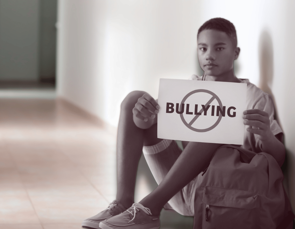 Teen holds sign which says "no bullying"