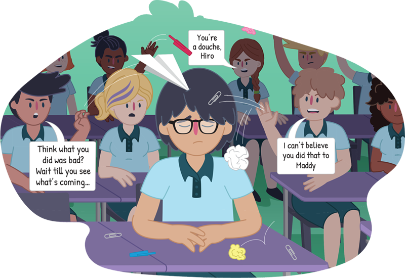 Boy looking sad as he sits at his school desk while other students throw things at him and insult him