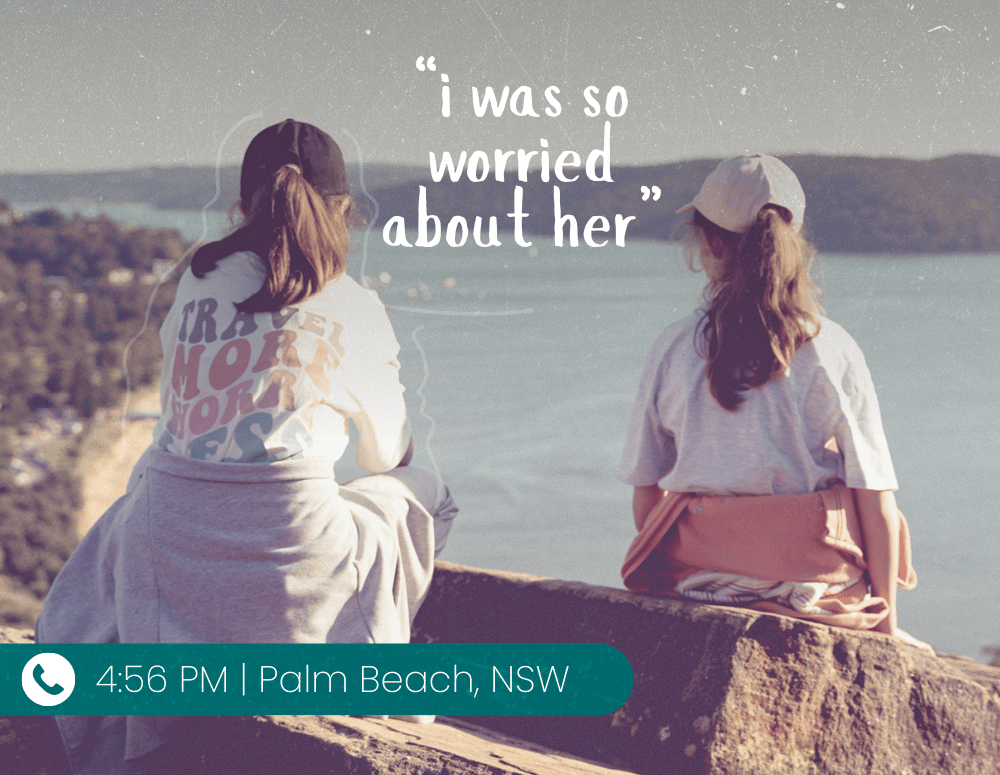 Two girls sitting looking at the ocean