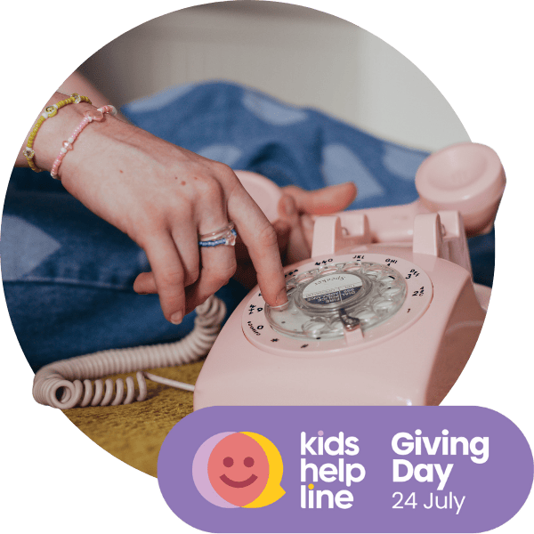A girl's hand reaches for a rotary phone. The image says "Kids Helpline Giving Day. 24 July."