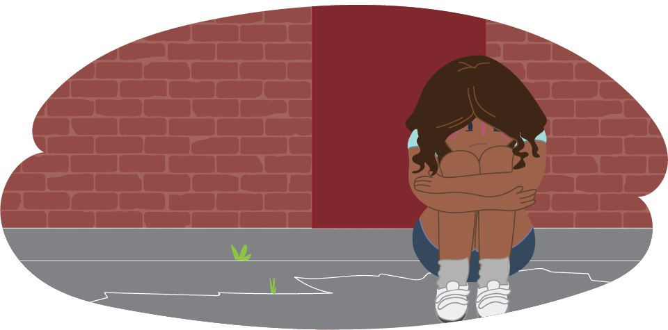 Girl with her head in her knees against a brick wall